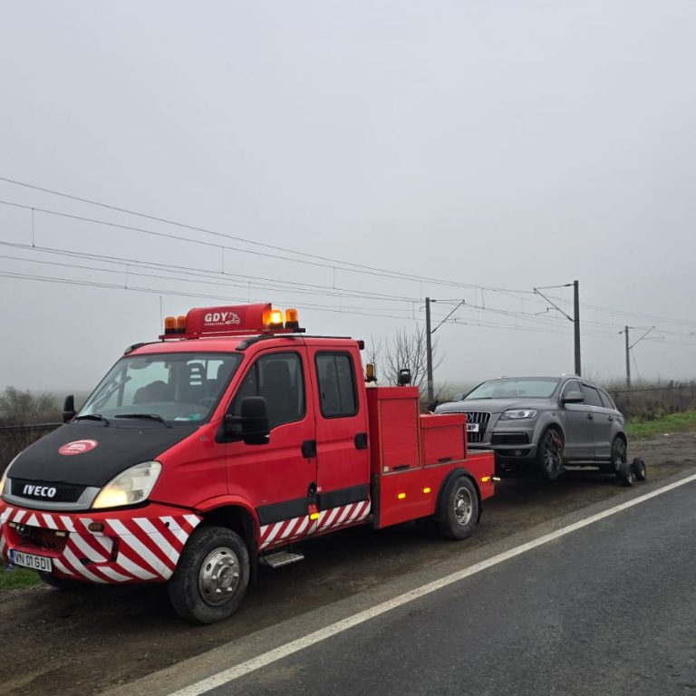 Asistență rutieră Focșani - camionetă roșie de tractare cu mașină preluată pe drum național